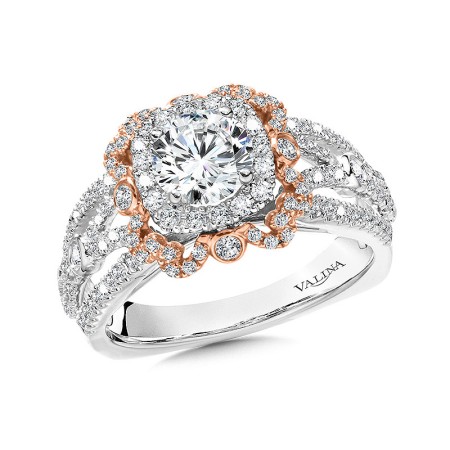 This unique ring features a regular cushion-shaped halo directly around the center stone. But around the halo lies another intricately detailed halo in rose gold with larger bezeled diamonds and smaller accent diamonds. This decorative halo creates a brig